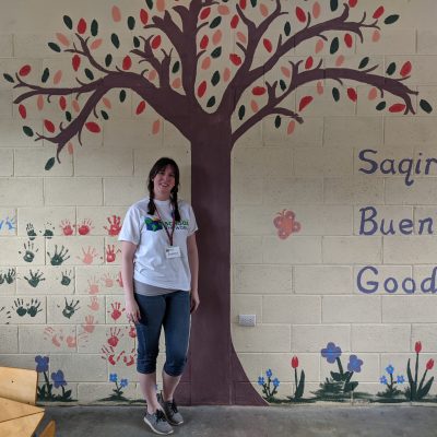 Jessica Ennis poses in front of her classroom mural in Guatemala